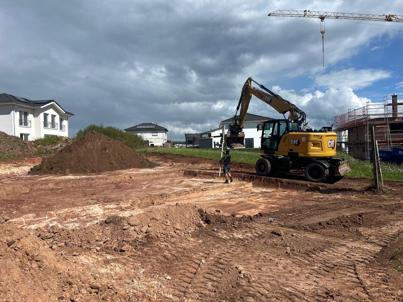 Baumaschine der Firma Stoll bei Erdarbeiten auf einer Baustelle
