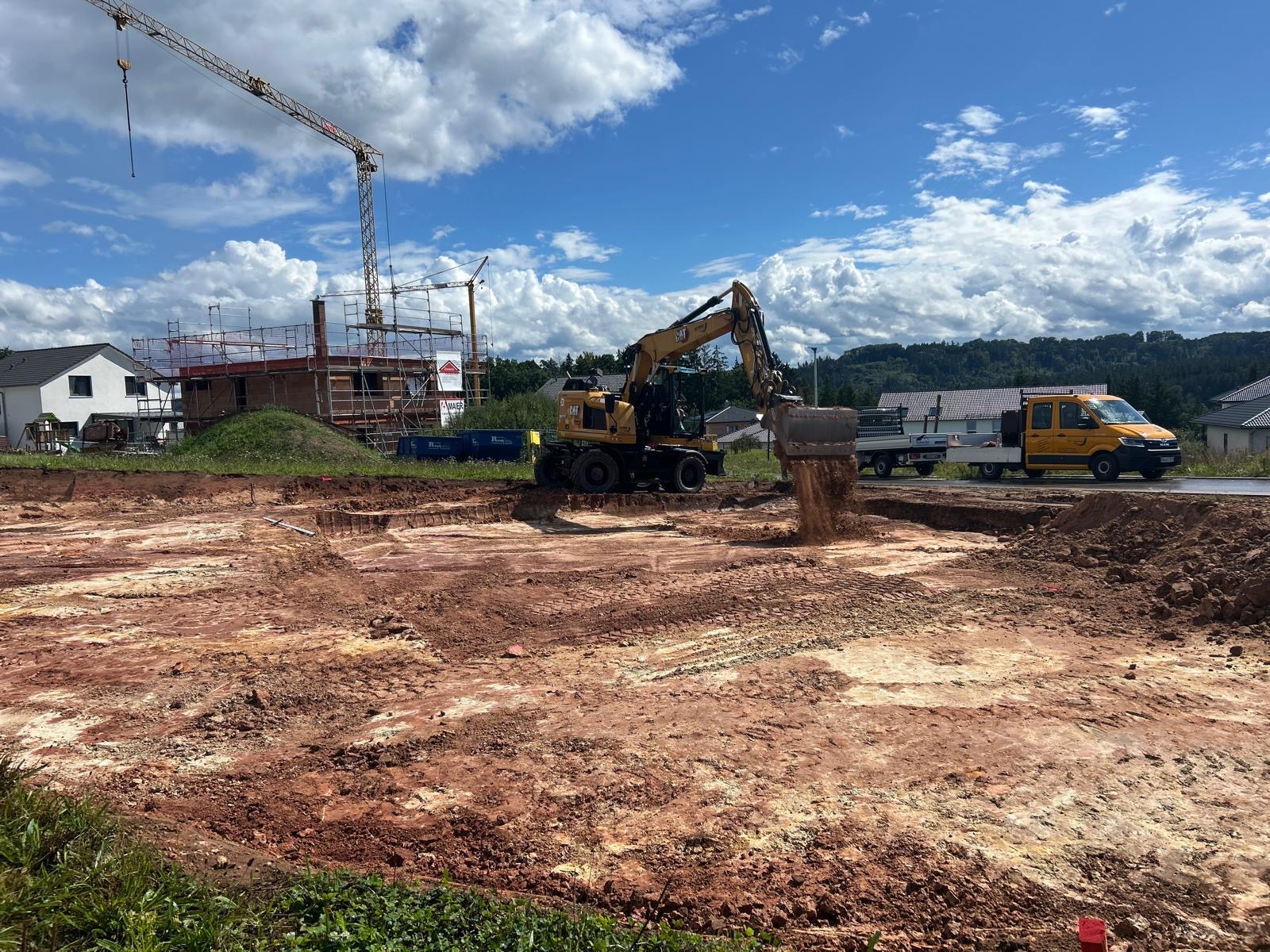 Bagger der Firma Stoll beim Abtragen und Planieren von Erdreich